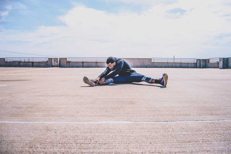 Foto de un hombre que se extiende al aire libre.