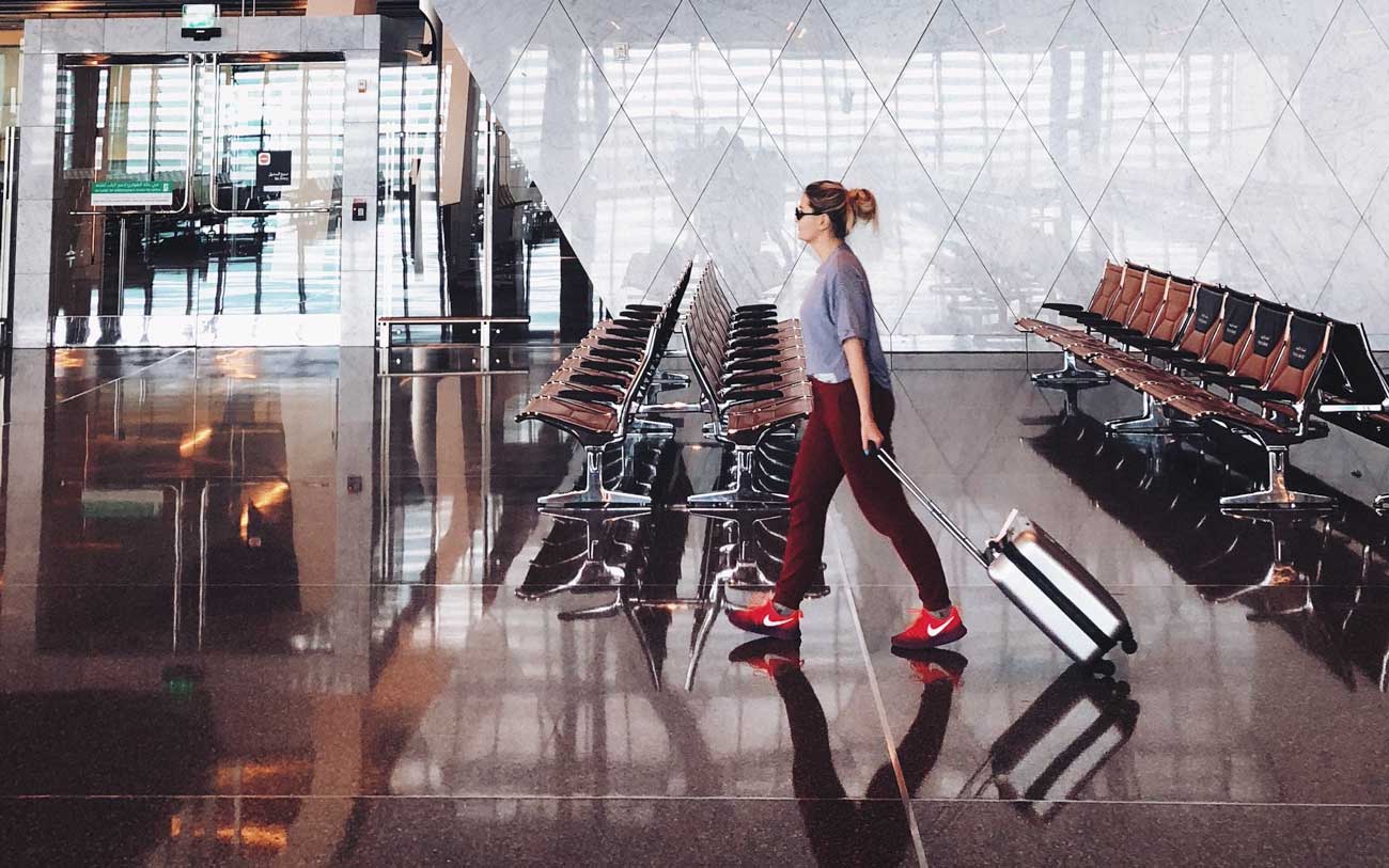 Mujer caminando por el aeropuerto con maleta