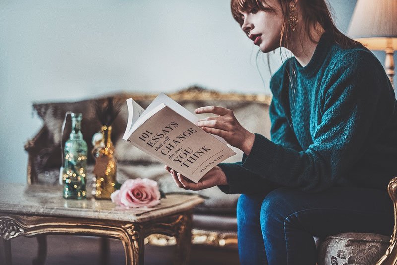 Foto de una mujer leyendo un libro de ensayos.