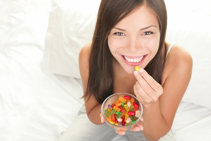 Mujer joven comiendo gomitas de CBD